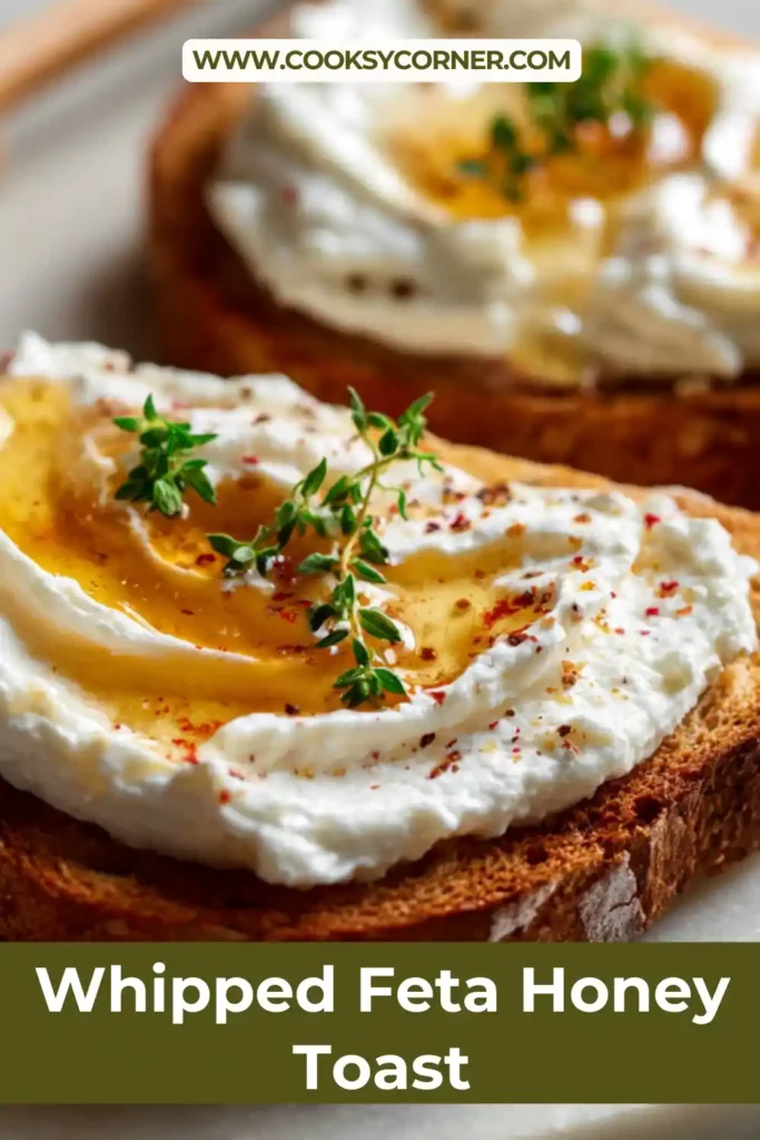 Creamy whipped feta honey toast topped with fresh herbs and drizzled with golden honey on toasted baguette slices.