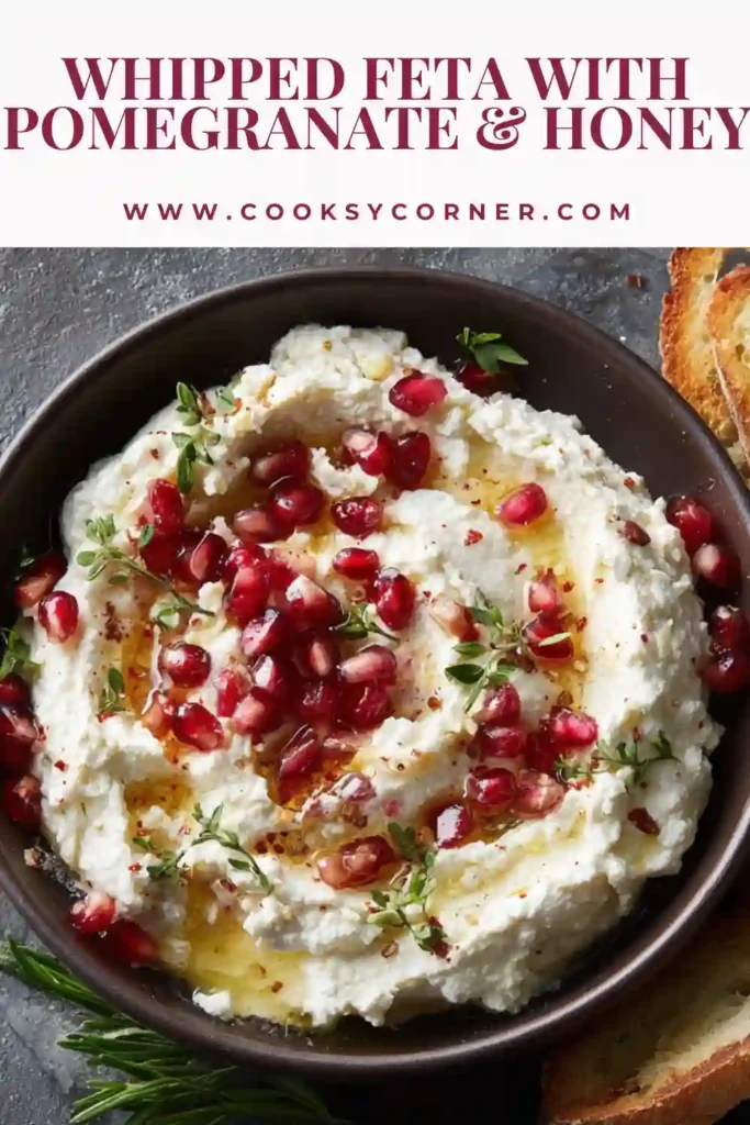 Whipped feta dip spread on a plate and topped with nuts and fruit, surrounded by warm pita wedges for dipping. A visually appealing and delicious dish.