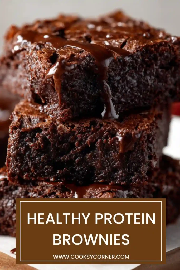 Freshly baked protein brownies cooling in a baking pan with visible chocolate chips throughout. The brownies have a soft and fudgy center ideal for a high protein snack.