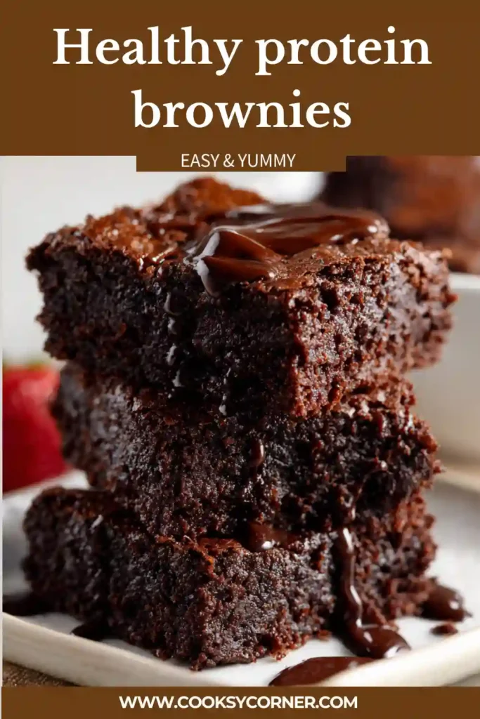 A stack of rich protein brownies made with almond butter and chocolate protein powder on a rustic serving plate. These healthy brownies have a fudgy texture with melted chocolate chips on top.