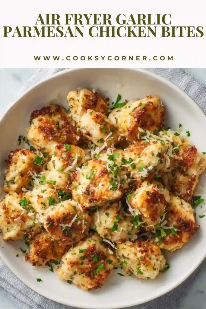 A bowl of Air Fryer Garlic Parmesan Chicken Bites garnished with freshly grated Parmesan cheese and chopped parsley. The crispy golden chicken pieces are perfectly cooked and ready to serve as a quick family-friendly meal.