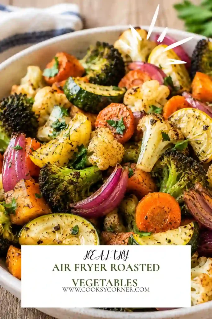 Homemade Air Fryer Roasted Vegetables arranged in a serving bowl with fresh herbs. The vegetables appear golden, tender, and perfectly seasoned.