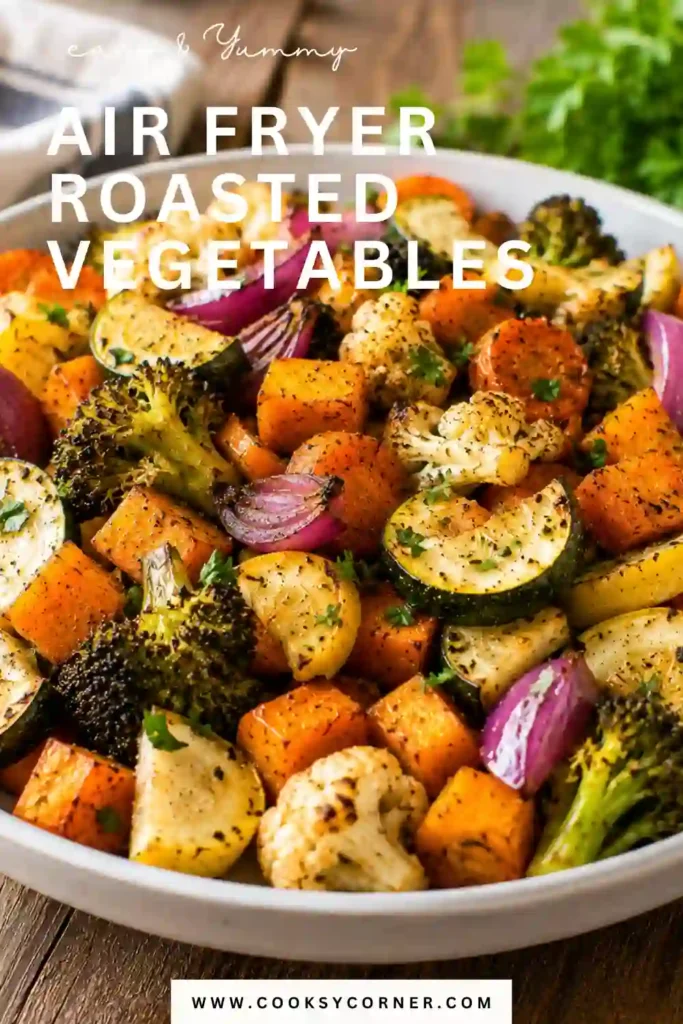 Freshly cooked air fryer vegetables garnished with parsley and served with lemon wedges. The vegetable medley features crisp-tender broccoli, cauliflower, zucchini, and sweet potato.