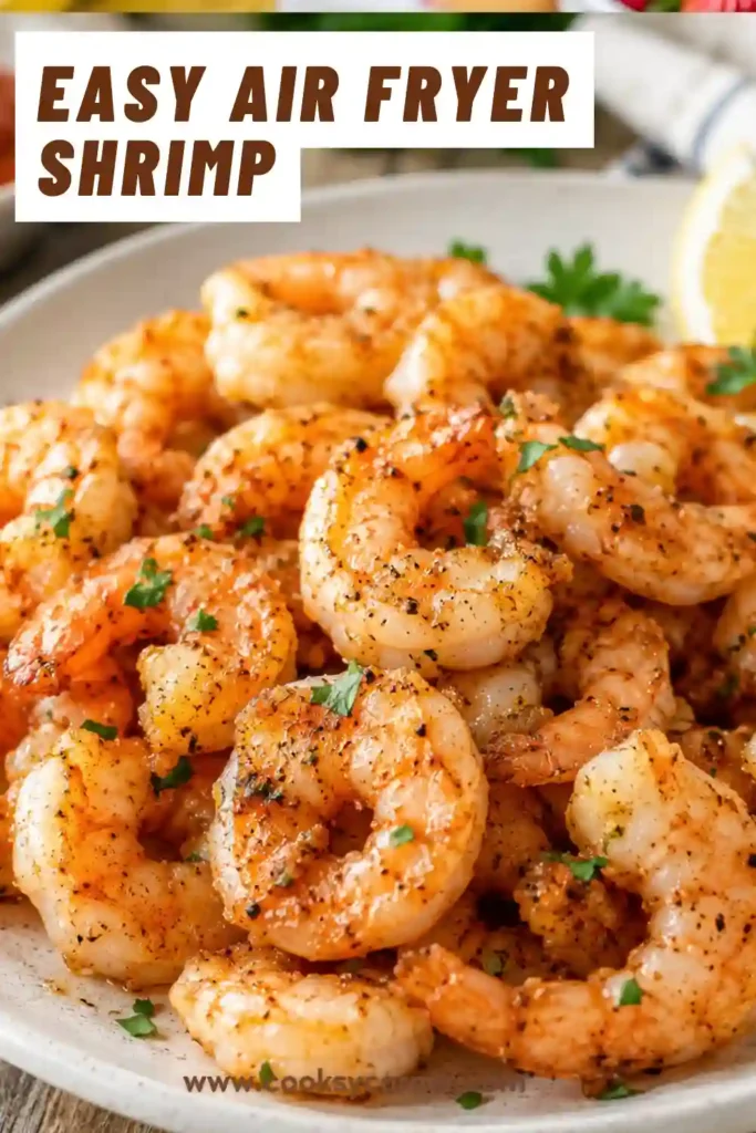 Golden Air Fryer Shrimp served with fresh lemon wedges on a white serving plate. The shrimp are juicy, lightly seasoned, and cooked until perfectly tender.