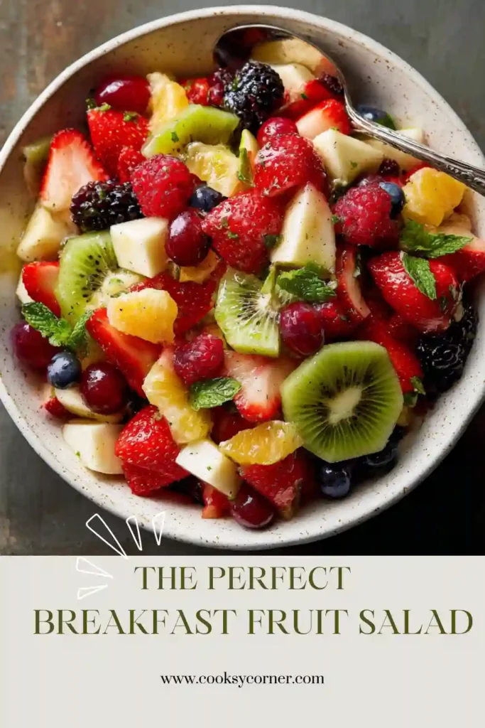 A bowl of Breakfast Fruit Salad filled with pineapple, strawberries, blueberries, blackberries, grapes, kiwi, and oranges tossed in citrus dressing.