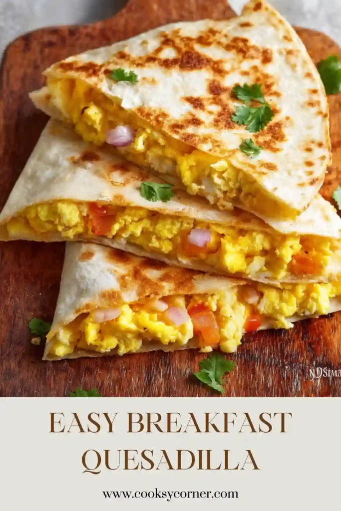 A crispy Breakfast Quesadilla filled with scrambled eggs, melted cheese, turkey ham, and fresh tomatoes. The quesadilla is sliced into wedges and served warm.