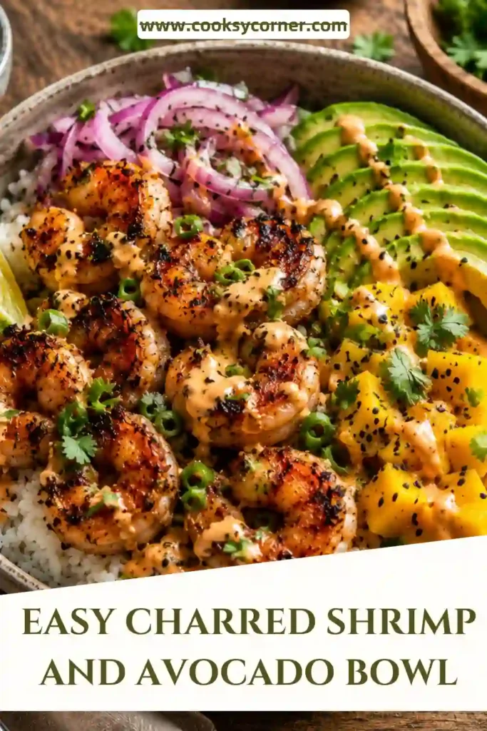 Healthy shrimp rice bowl featuring charred shrimp, creamy avocado, fresh mango salsa, and lime-chili drizzle. A balanced seafood meal served in a shallow bowl.
