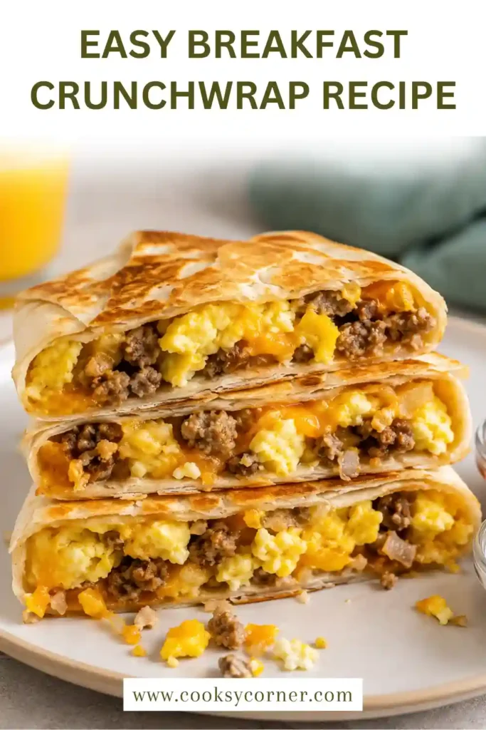 A homemade Breakfast Crunchwrap cut in half to reveal layers of scrambled eggs, beef sausage, melted cheese, and crispy hash browns inside a toasted tortilla.