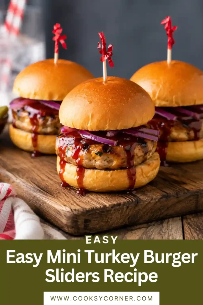 Turkey cheeseburger sliders arranged on a serving platter with lettuce, tomato, and pickles.