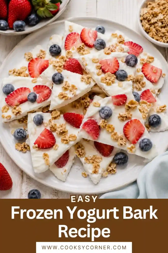 Frozen Yogurt Bark topped with fresh strawberries, blueberries, and granola on a parchment-lined tray. This healthy frozen dessert is colorful, refreshing, and easy to make.
