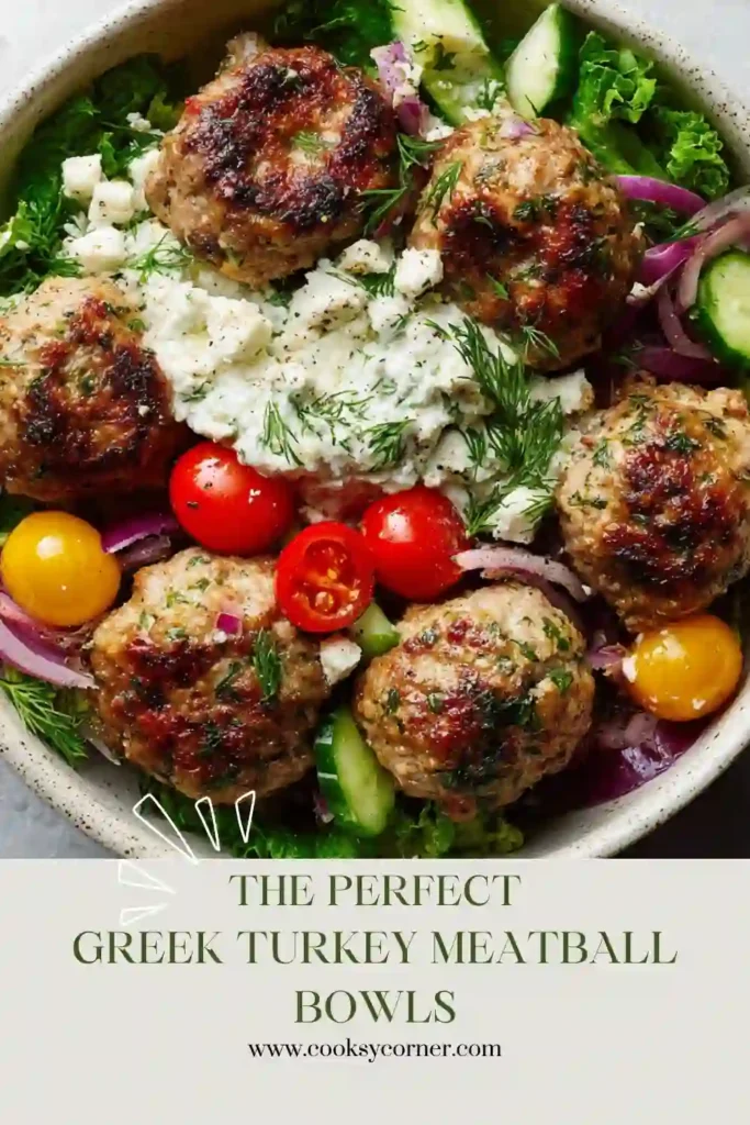Mediterranean turkey meatballs arranged over quinoa and greens with cherry tomatoes, cucumbers, feta cheese, and tzatziki sauce. A nutritious and easy weeknight dinner.