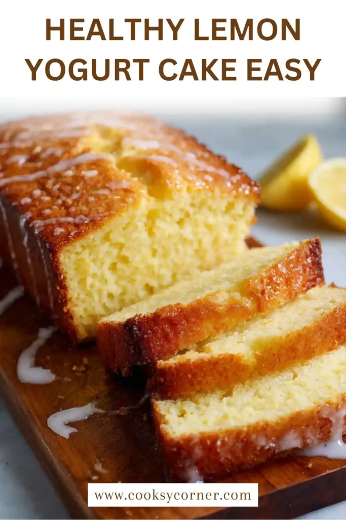 A close-up of a slice of lemon yogurt cake with glossy lemon glaze and visible lemon zest. The interior looks soft and fluffy.