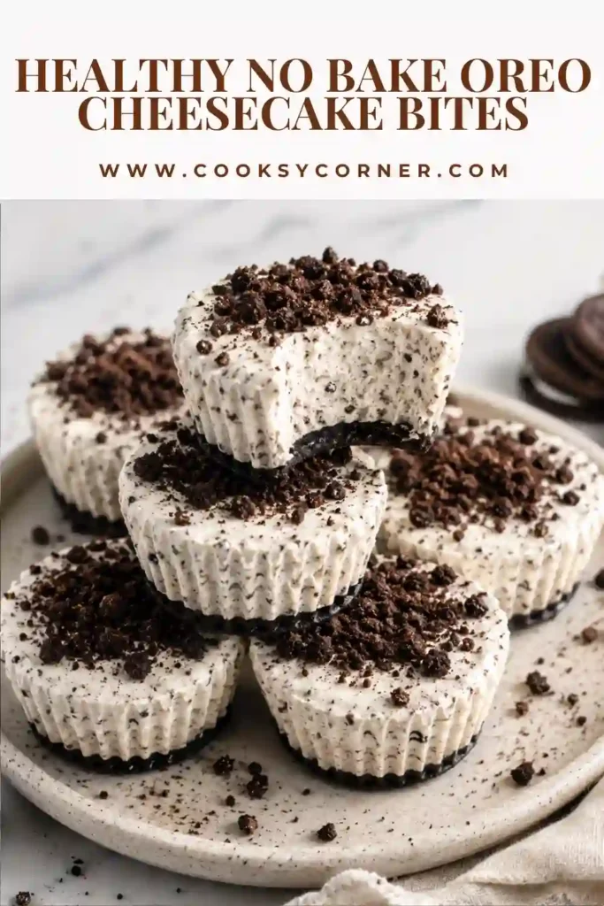 Healthy no-bake Oreo cheesecake bites served in cupcake liners and topped with crushed Oreo cookies.