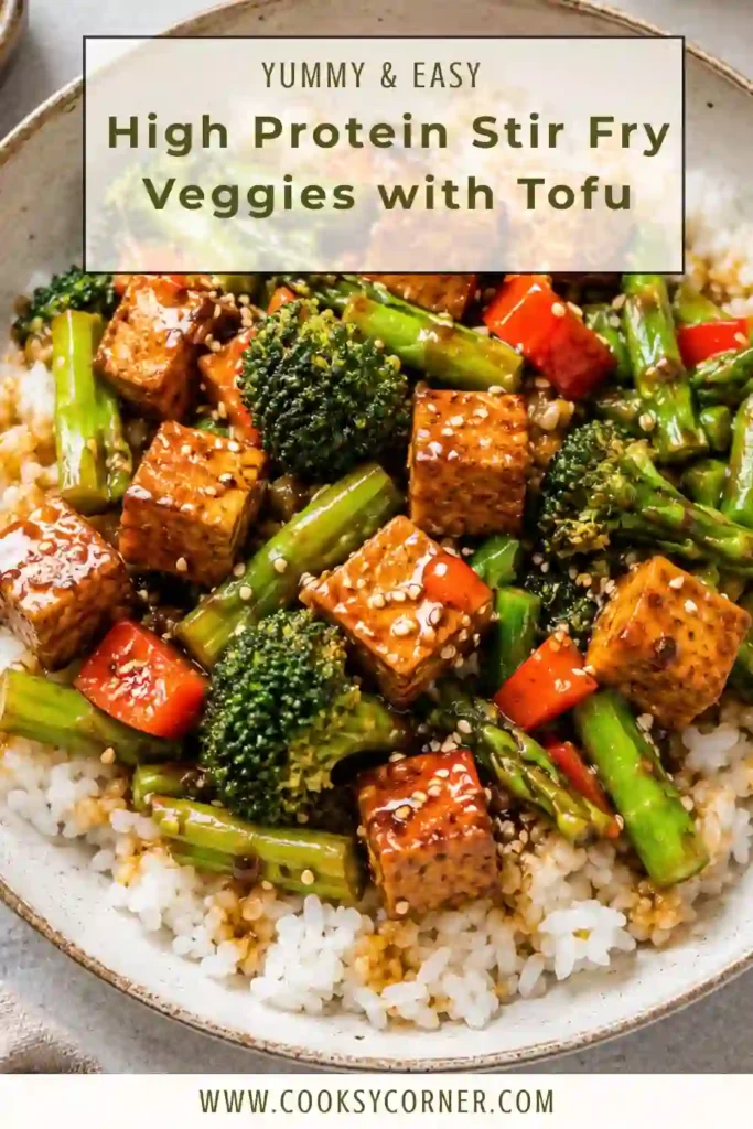 A bowl of High Protein Stir Fry Veggies with Tofu garnished with basil and green onions alongside chopsticks.
