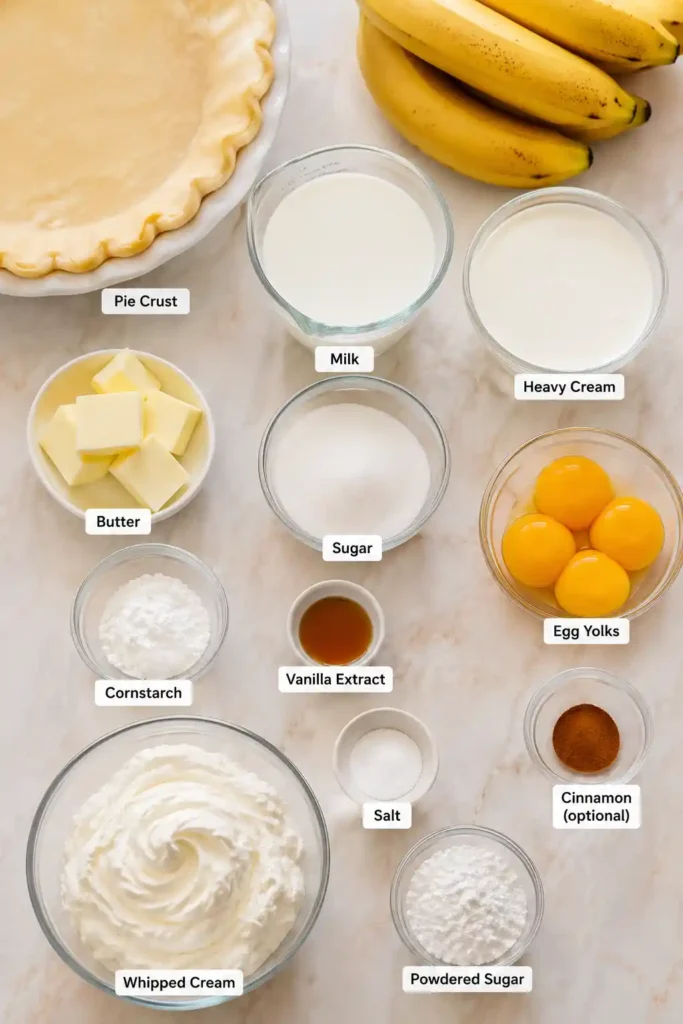 A slice of Homemade Banana Cream Pie topped with fresh whipped cream and banana slices. The creamy vanilla custard filling rests inside a flaky golden pie crust.