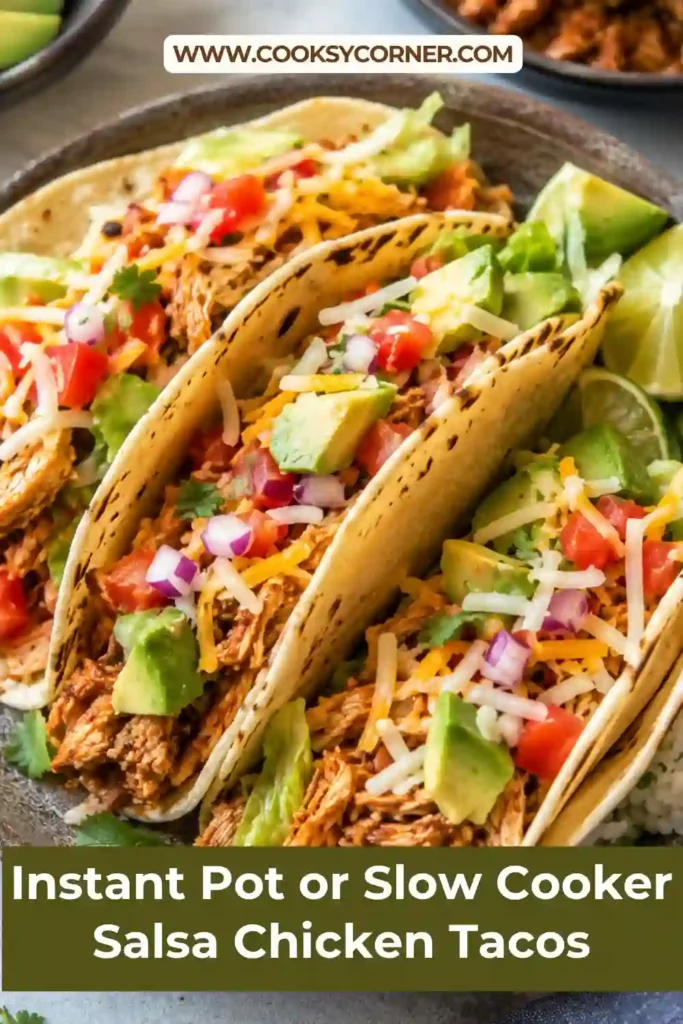Slow cooker salsa chicken tacos topped with avocado, shredded lettuce, tomatoes, cheese, and cilantro.
