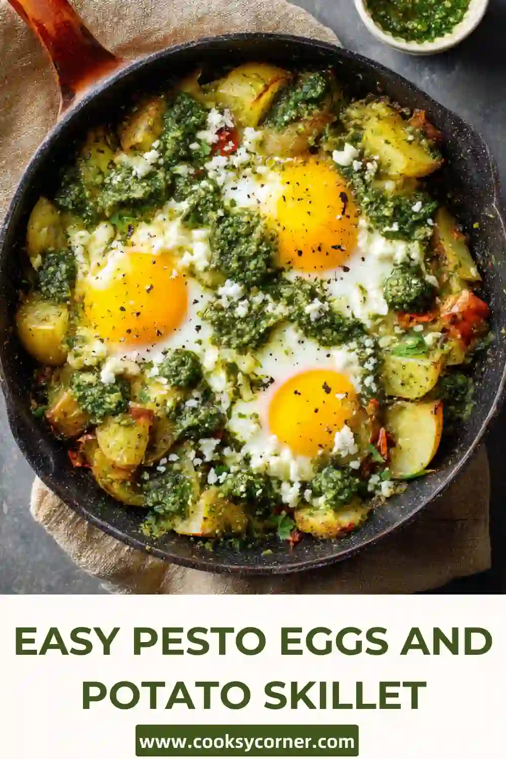 One-pan potato and egg skillet topped with basil pesto and crumbled feta.