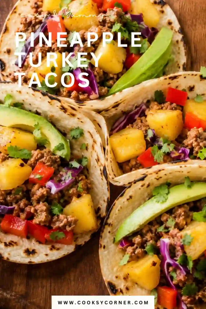A platter of Pineapple Turkey Tacos garnished with avocado, cilantro, shredded lettuce, and lime wedges.