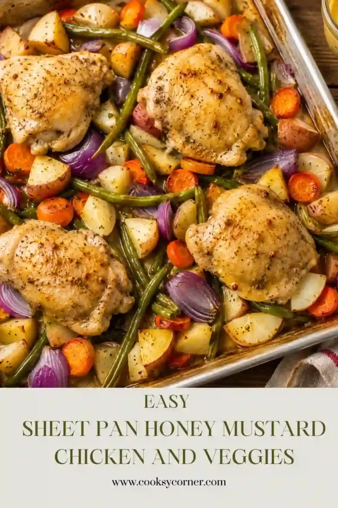 A close-up of roasted honey mustard chicken thighs served with crispy potatoes, tender carrots, green beans, and onions on a sheet pan.