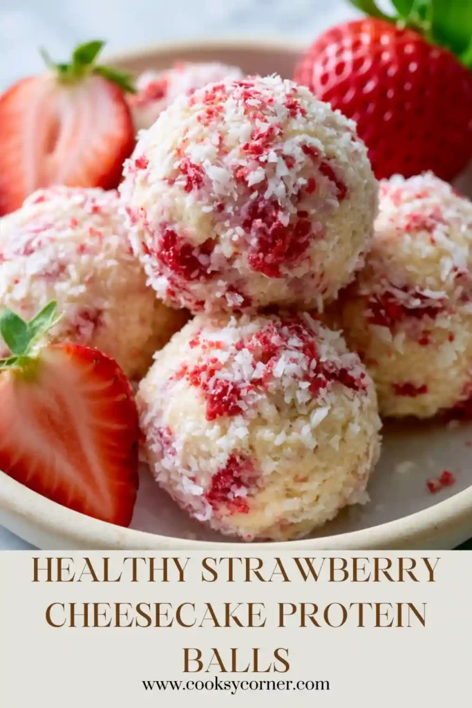 A plate of Strawberry Cheesecake Protein Balls coated with crushed freeze-dried strawberries. These no-bake protein bites have a creamy texture and vibrant strawberry flavor.