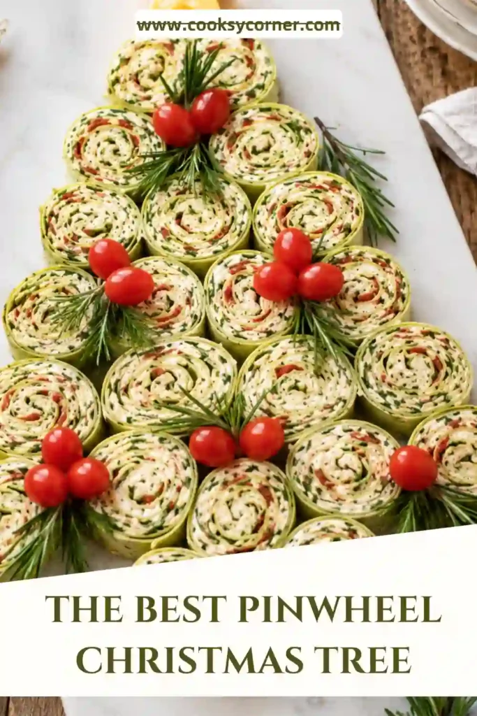 Creamy chicken pinwheels displayed in a Christmas tree pattern on a wooden platter. The festive appetizer features spinach wraps, vegetables, and holiday-inspired garnishes.