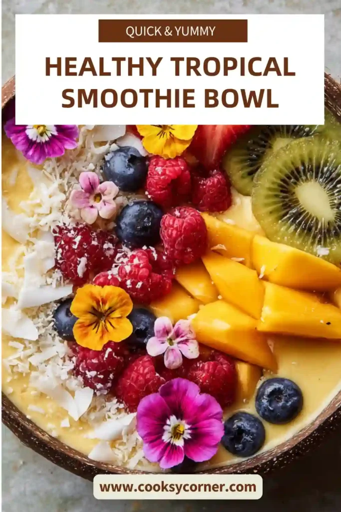 Strawberry mango smoothie bowl topped with kiwi, coconut flakes, blueberries, and raspberries.