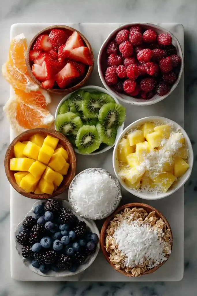 Bright smoothie bowl served with fresh fruit toppings and crunchy granola on a light background.