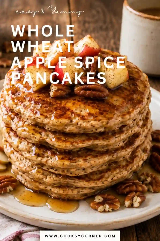 Freshly cooked apple spice pancakes made with whole wheat flour and topped with pure maple syrup. The pancakes have a hearty texture and comforting homemade appearance.