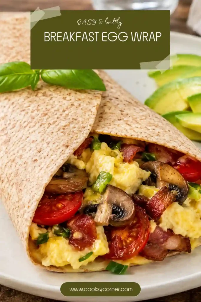 A Breakfast Egg Wrap filled with fluffy scrambled eggs, sautéed mushrooms, cherry tomatoes, and turkey ham wrapped in a whole wheat tortilla. This healthy breakfast wrap is served fresh and warm.