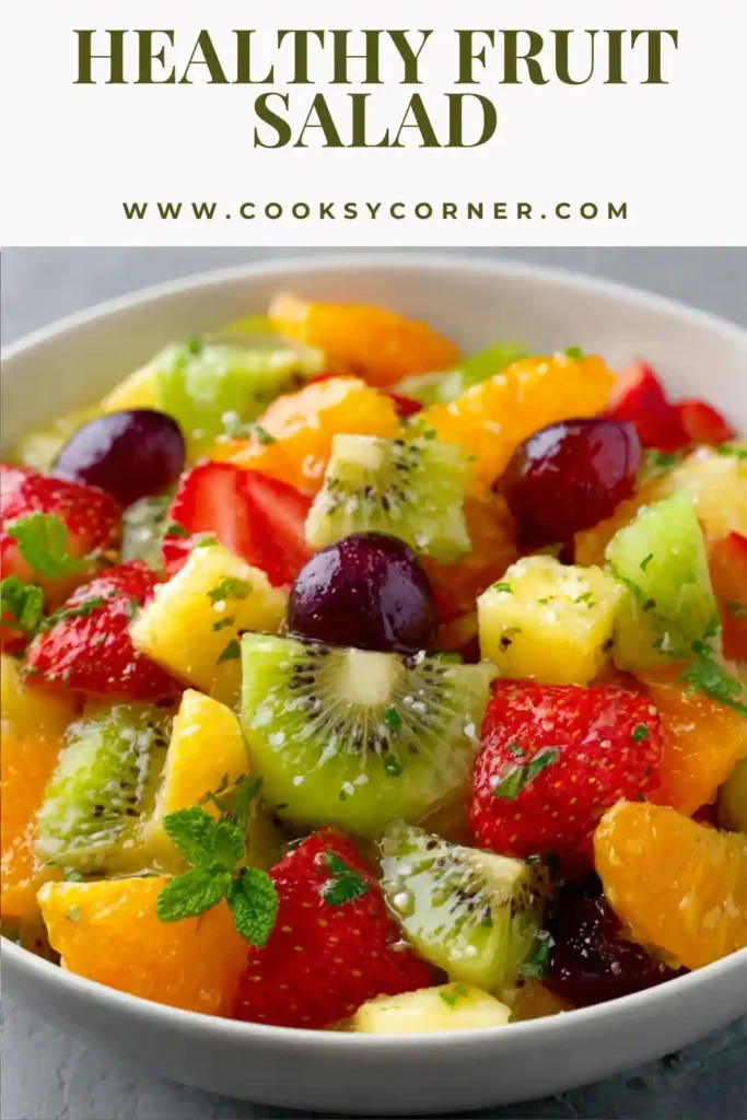 Colorful fruit salad in a serving bowl featuring mixed berries, tropical fruit, and citrus dressing. A refreshing side dish perfect for brunches, parties, and picnics.