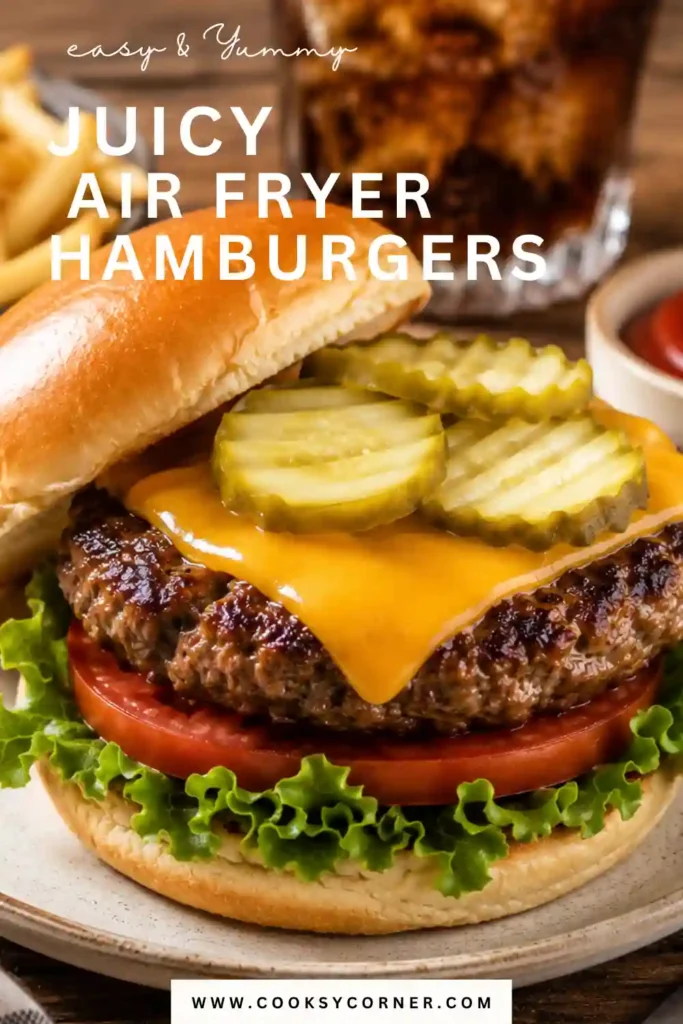 Close-up of a juicy Air Fryer Hamburger topped with lettuce, tomato, and pickles. The burger is served on a toasted bun with a perfectly cooked beef patty.