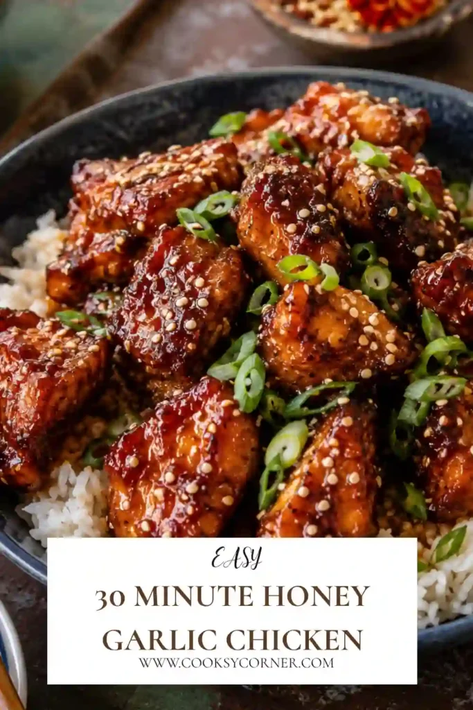 Freshly baked 30 Minute Honey Garlic Chicken served with roasted broccoli on a sheet pan. The chicken is coated in a glossy honey garlic sauce and garnished with sesame seeds and green onions.