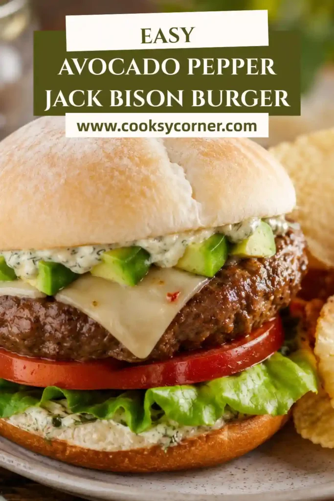 Freshly grilled bison burger layered with creamy avocado, Pepper Jack cheese, crisp lettuce, tomato, and herbed mayonnaise on a bakery bun. A healthy and flavorful burger packed with protein.