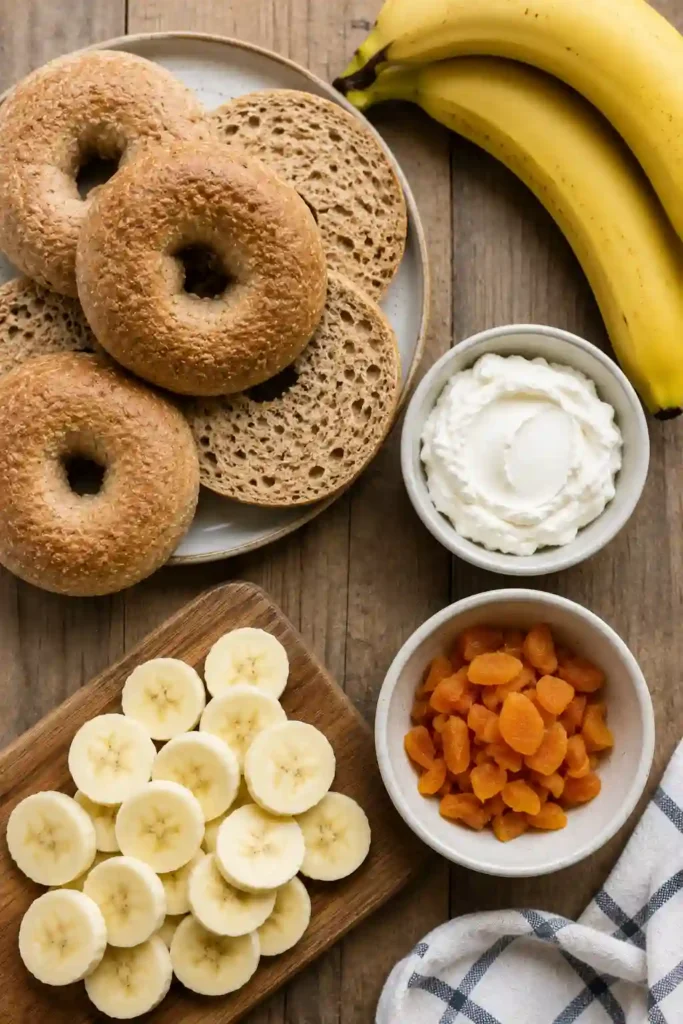Homemade fruit bagels filled with bananas, dried apricots, and soft cheese on a breakfast plate.