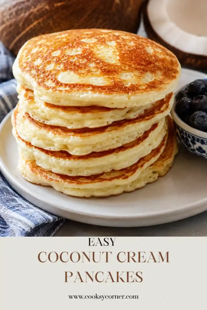 A stack of fluffy Coconut Cream Pancakes topped with butter, maple syrup, and toasted coconut flakes. These homemade coconut milk pancakes make a delicious tropical breakfast.