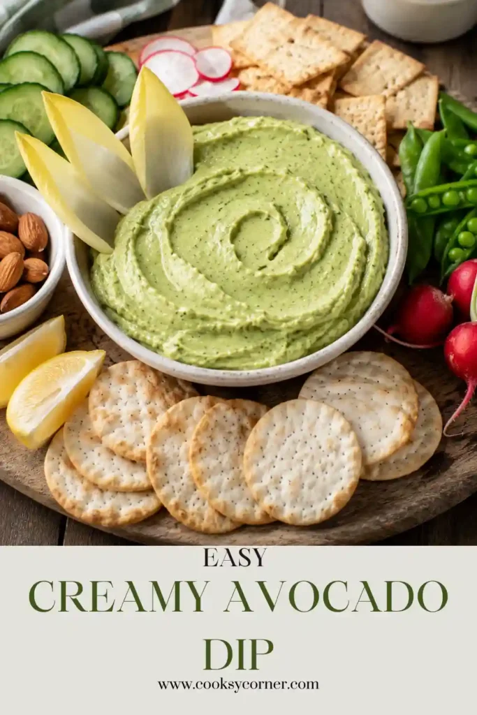 Smooth avocado yogurt dip garnished with chopped dill and paired with carrot sticks, cucumber slices, and bell peppers.