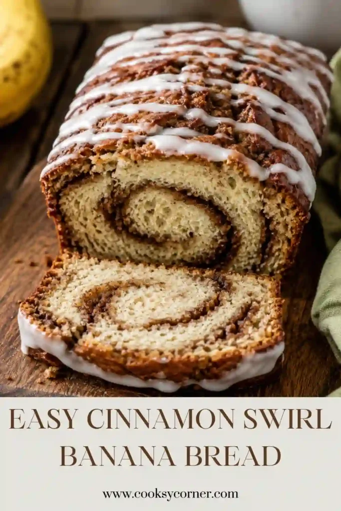 Freshly baked Cinnamon Swirl Banana Bread topped with smooth vanilla icing and sliced on a wooden cutting board. The loaf has visible cinnamon swirls and a moist, tender crumb.