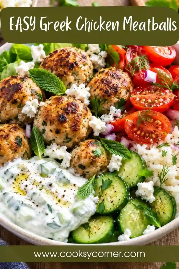 Homemade Greek Chicken Meatballs garnished with fresh herbs and served alongside rice, cucumber, tomatoes, and creamy yogurt sauce.