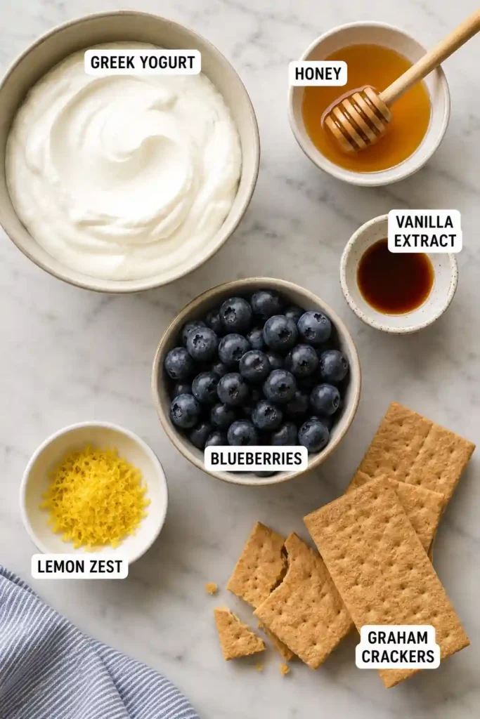 Frozen Greek yogurt bark featuring juicy blueberries, bright lemon zest, and crisp graham cracker topping. A refreshing homemade dessert with simple ingredients.
