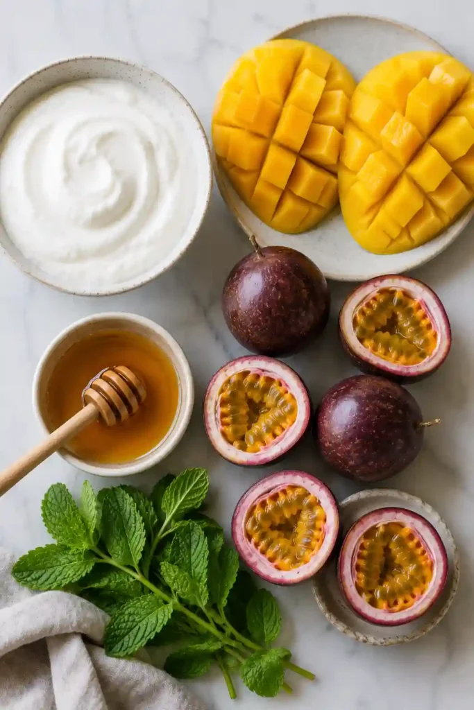 Refreshing Greek yogurt dessert layered with tropical fruit and garnished with fresh mint.