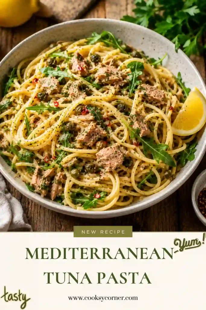 A bowl of Mediterranean Tuna Pasta with spaghetti, flaky albacore tuna, fresh arugula, lemon zest, capers, and parsley. The colorful ingredients create a light, healthy, and flavorful Mediterranean-inspired meal.