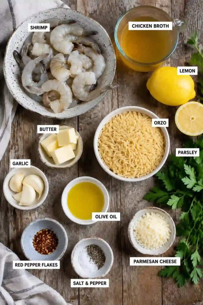 Shrimp Orzo in Lemon Garlic Sauce served in a white bowl with fresh parsley and lemon wedges on the side. The simple ingredients create a bright and elegant seafood dish.