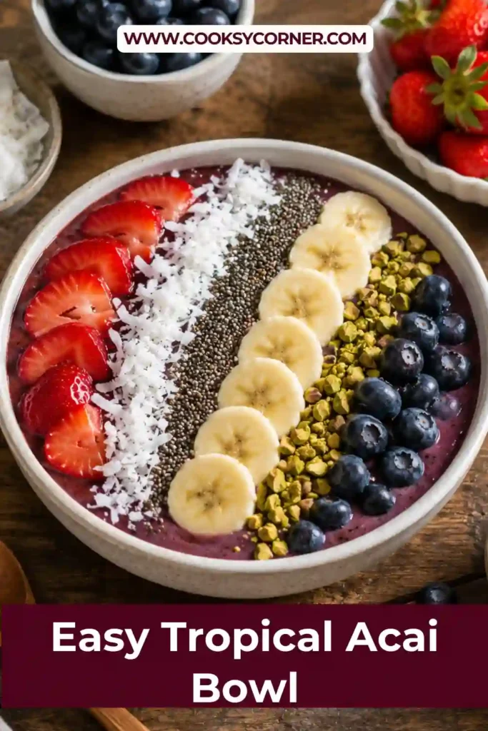 A homemade Tropical Acai Bowl served with fresh strawberries, blueberries, and kiwi slices. The smoothie bowl has a rich purple color and a creamy texture made from frozen acai and tropical fruit.