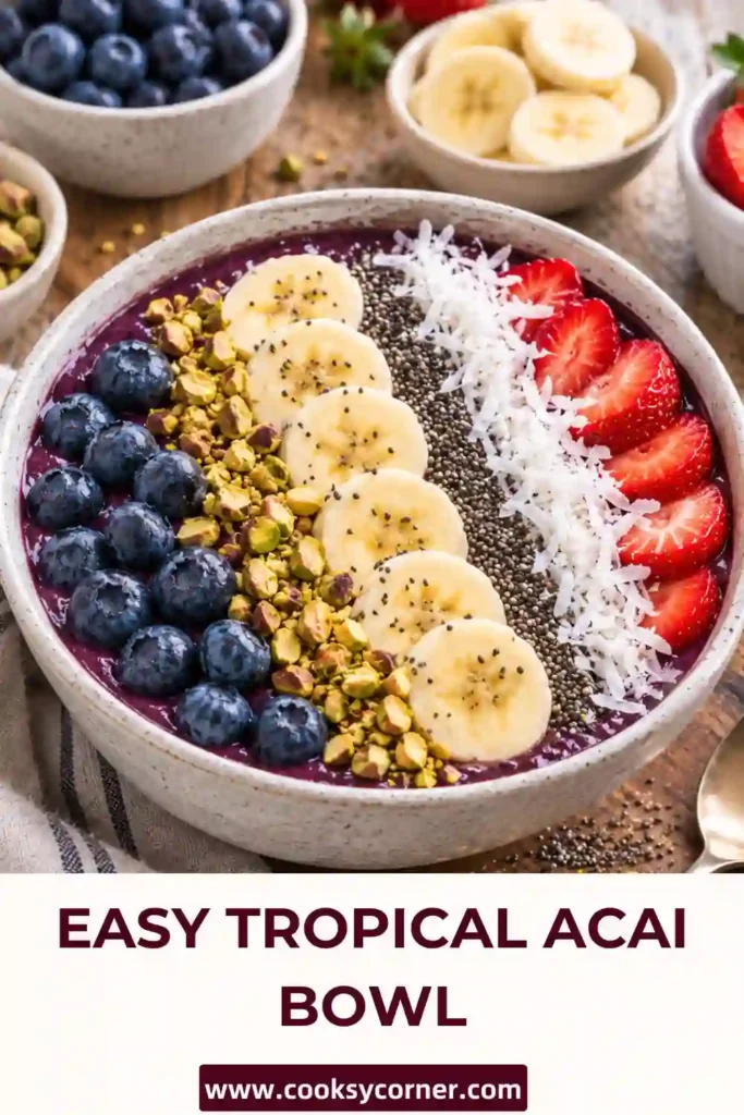 A thick Tropical Acai Bowl topped with blueberries, sliced kiwi, and fresh strawberries in a serving bowl. This colorful healthy breakfast features frozen acai blended with banana, pineapple, and creamy coconut milk.
