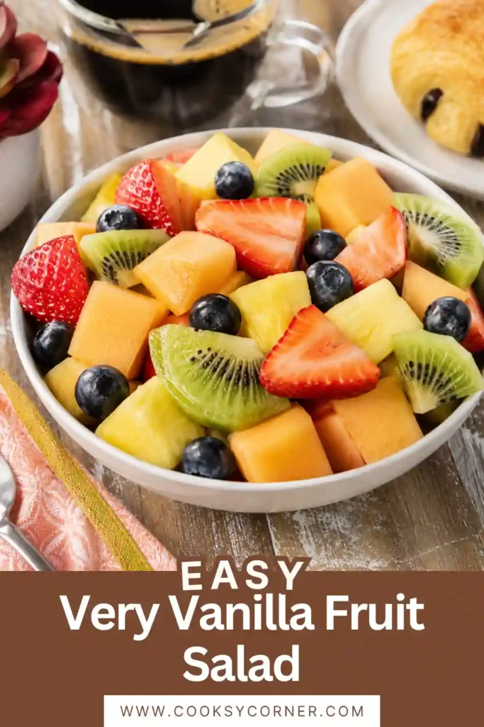 A bowl of Very Vanilla Fruit Salad filled with strawberries, blueberries, pineapple, cantaloupe, and kiwi. The fresh fruit is coated with a light vanilla flavor and served chilled for a refreshing dessert.