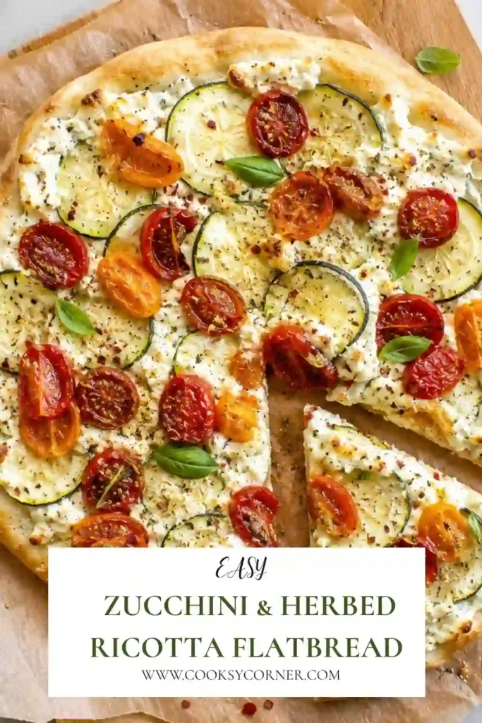 A sliced vegetarian flatbread topped with zucchini, herbed ricotta, roasted tomatoes, and fresh basil. This Mediterranean-inspired recipe is perfect for lunch or dinner.