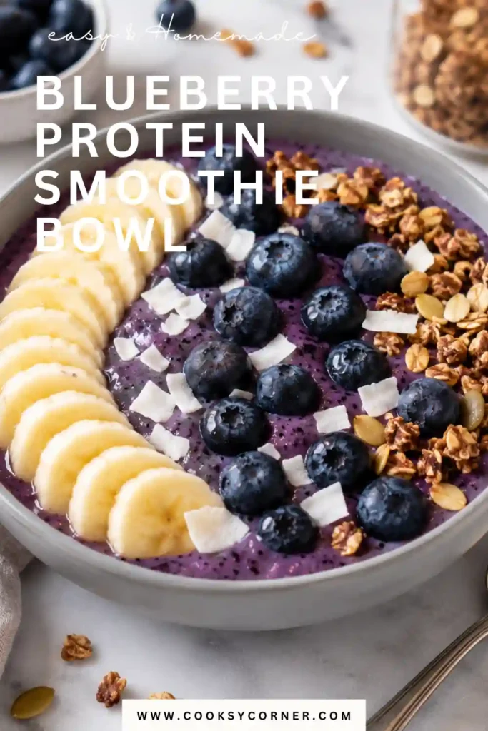 Creamy blueberry smoothie bowl served with crunchy granola, coconut flakes, and fresh fruit. A healthy high-protein breakfast that is colorful and refreshing.