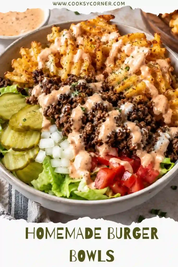 3. Close-up of a cheeseburger bowl featuring browned ground beef, crunchy lettuce, diced tomatoes, pickles, and golden waffle fries coated in ranch seasoning. A perfect bunless comfort meal.