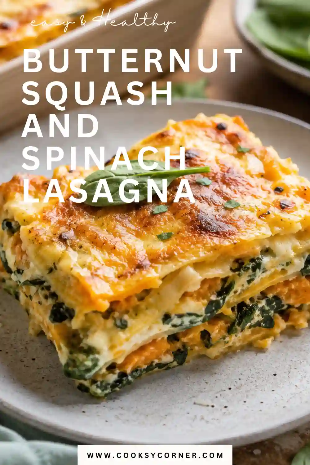 A sliced portion of butternut squash and spinach lasagna showing layers of creamy squash, green spinach, ricotta, pasta, and melted cheese. The vegetarian lasagna is baked until golden and bubbly.