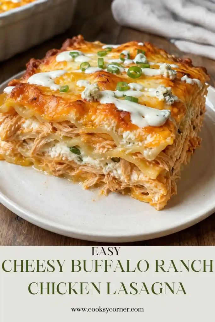 A sliced serving of Cheesy Buffalo Ranch Chicken Lasagna showing creamy chicken and buffalo cheese filling between tender pasta layers. Melted mozzarella and cheddar cover the top.
